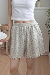 Model wearing Avauma Petitbloom mom shorts in rosy cream, styled with white top.